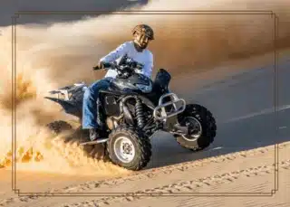 150cc quad bike riding through the desert terrain during a Desert Safari Dubai